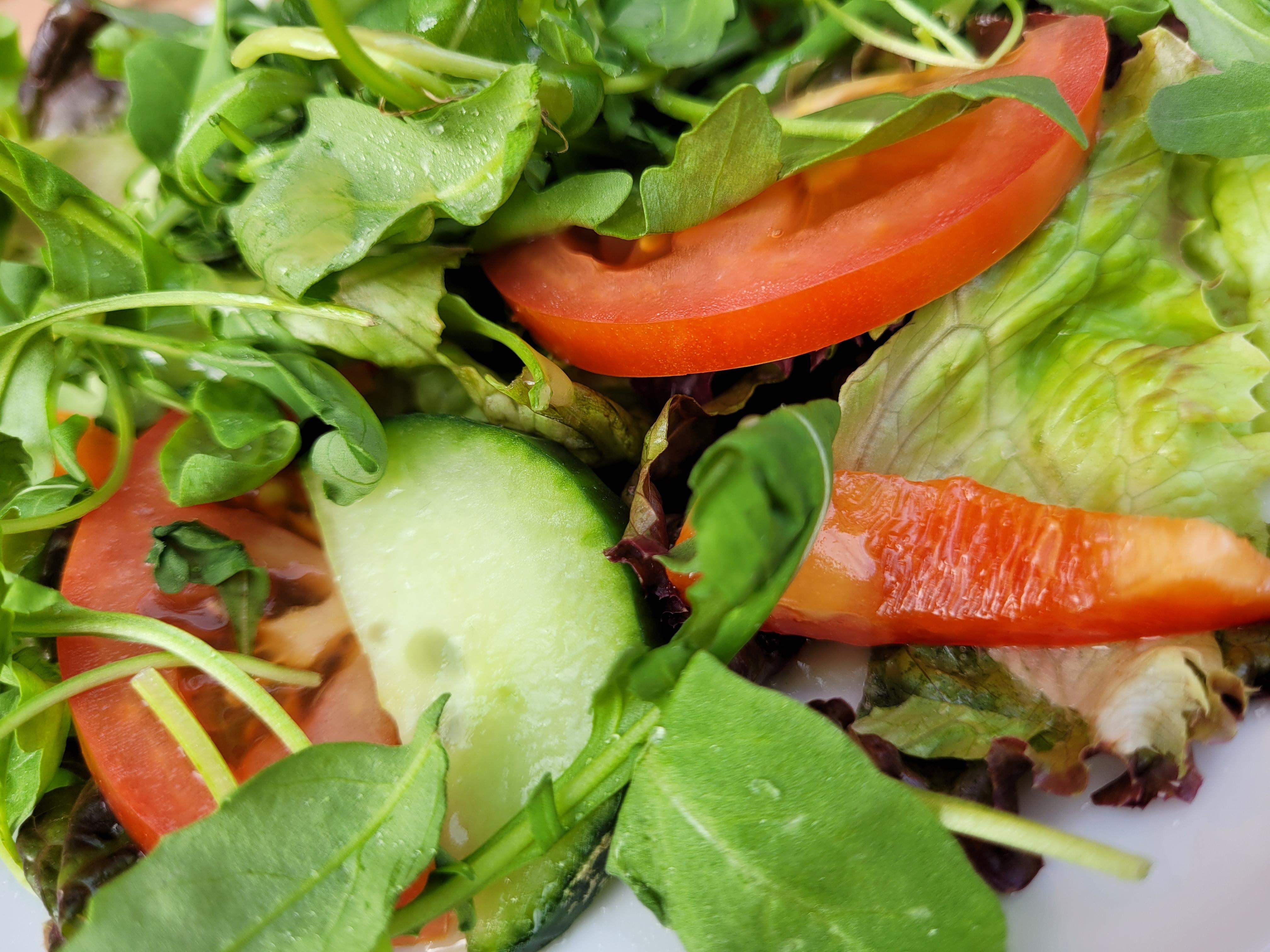 Zdjęcie na którym widać produkty wegetariańskie, pomidor, ogórek i zielone warzywa liściaste